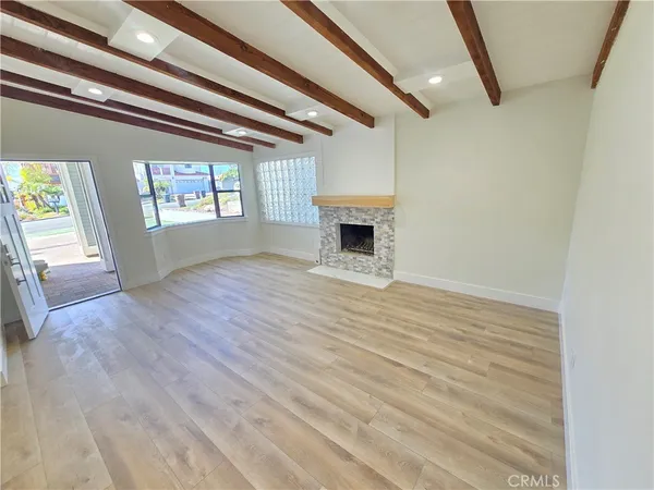 a view of empty room with wooden floor and fireplace