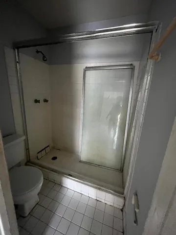 a bathroom with a granite countertop toilet and a shower