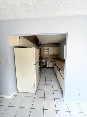 a kitchen with a refrigerator and a stove top oven
