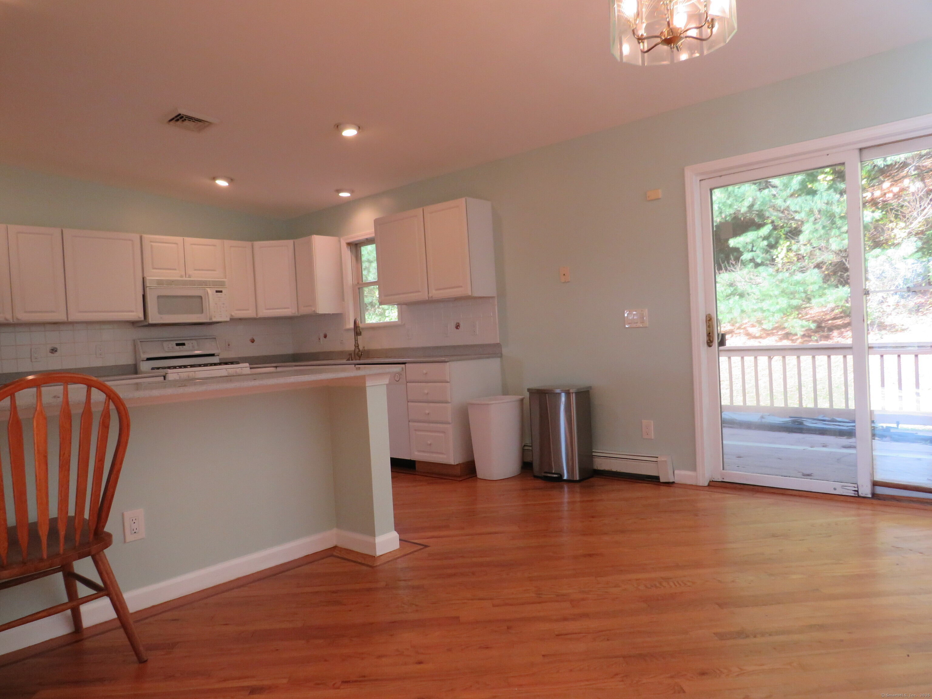 15 Hayestown Heights Danbury, CT 06811 - Photo 6 of 28 a kitchen with stainless steel appliances granite countertop a stove a sink a refrigerator and white cabinets with wooden floor