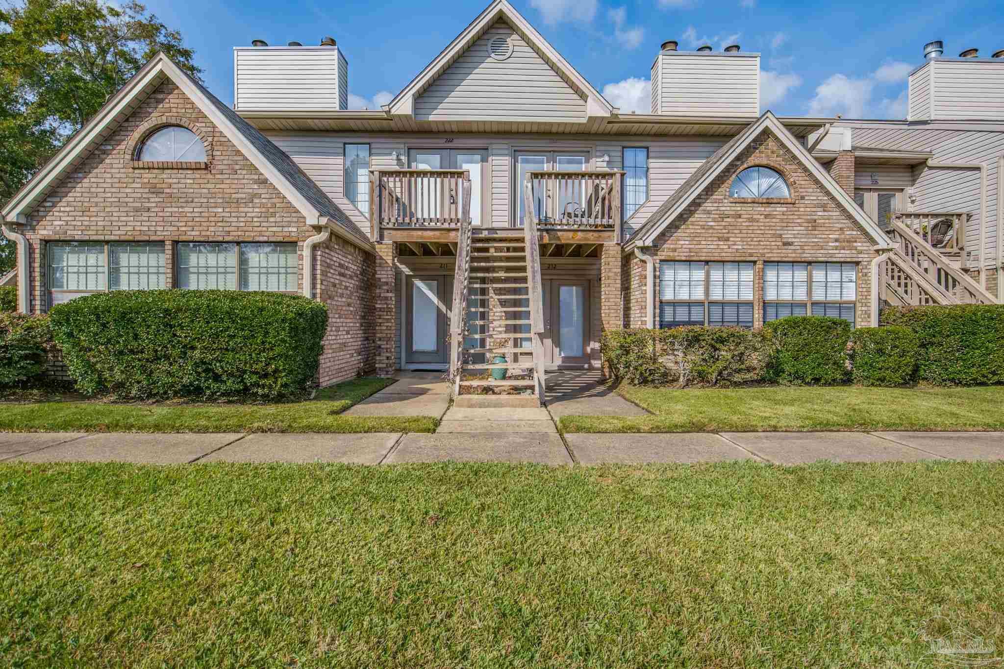 a front view of a house with a yard and plants