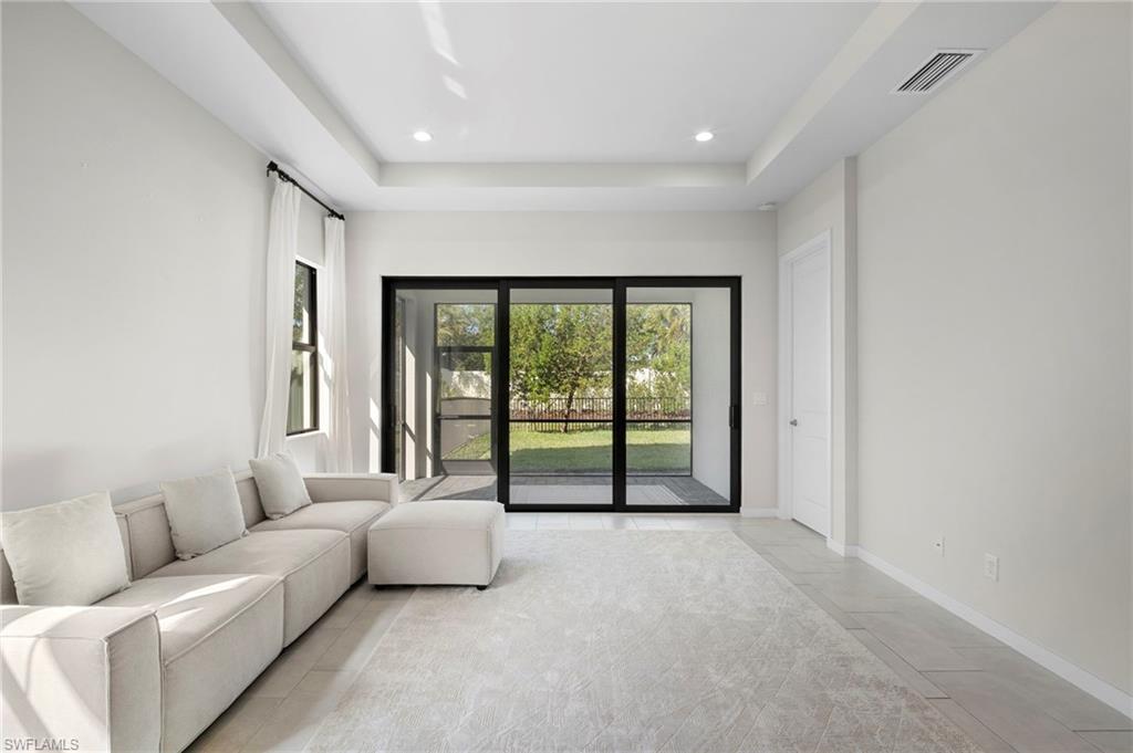 14720 Kingfisher Loop Naples, FL 34120 - Photo 10 of 50 Living room featuring a tray ceiling and recessed lighting