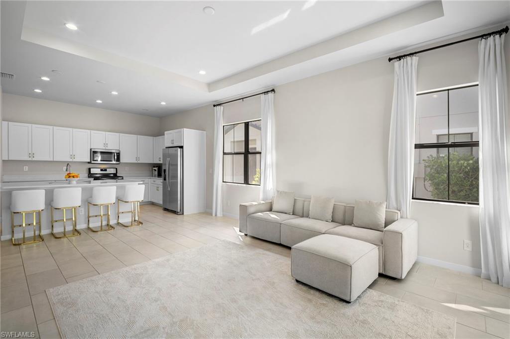 14720 Kingfisher Loop Naples, FL 34120 - Photo 13 of 50 Living area with a tray ceiling, recessed lighting, and light tile patterned floors