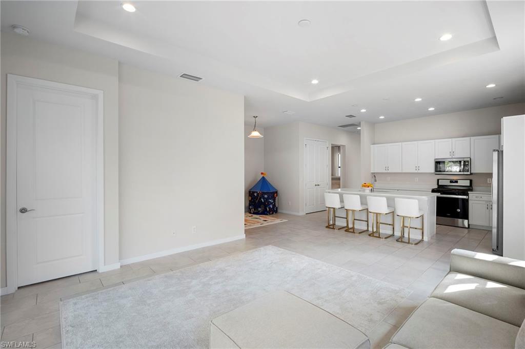 14720 Kingfisher Loop Naples, FL 34120 - Photo 14 of 50 Living area with a raised ceiling, recessed lighting, and light tile patterned floors
