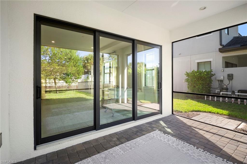 14720 Kingfisher Loop Naples, FL 34120 - Photo 18 of 50 Doorway with plenty of natural light and brick patterned flooring