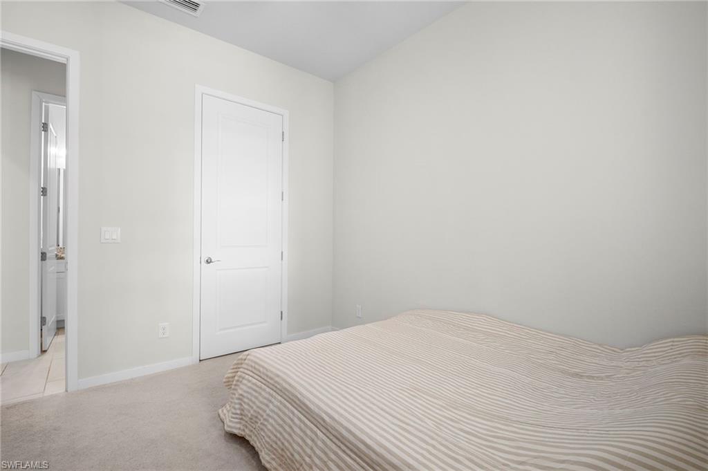 14720 Kingfisher Loop Naples, FL 34120 - Photo 20 of 50 Bedroom with light carpet and baseboards