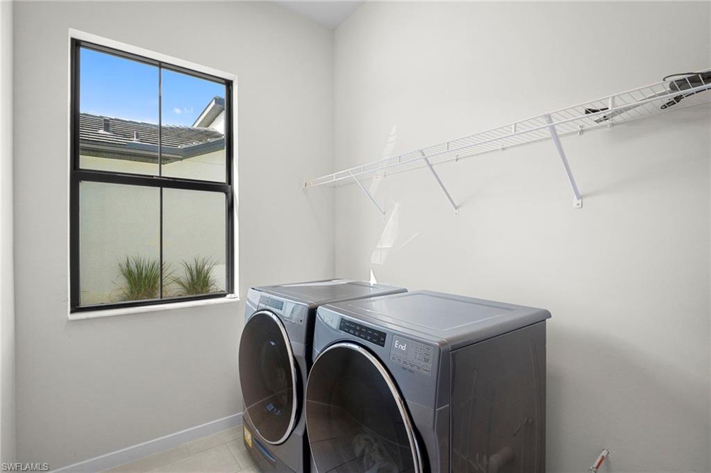 14720 Kingfisher Loop Naples, FL 34120 - Photo 22 of 50 Laundry area with separate washer and dryer and light tile patterned floors