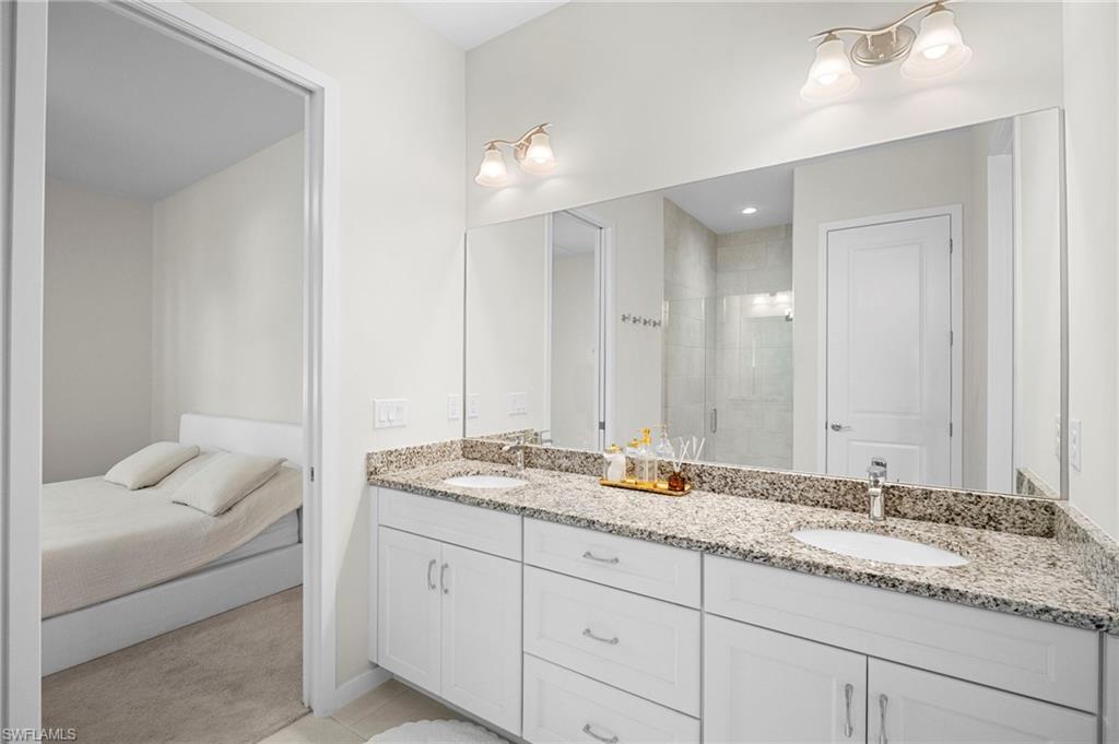 14720 Kingfisher Loop Naples, FL 34120 - Photo 30 of 50 Bathroom with double vanity, a stall shower, light colored carpet, and ensuite bathroom