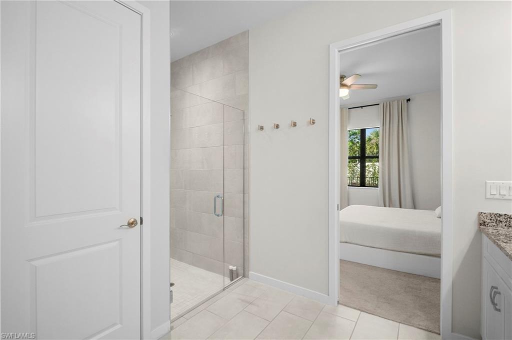 14720 Kingfisher Loop Naples, FL 34120 - Photo 31 of 50 Ensuite bathroom with a shower stall, vanity, light tile patterned flooring, and ceiling fan