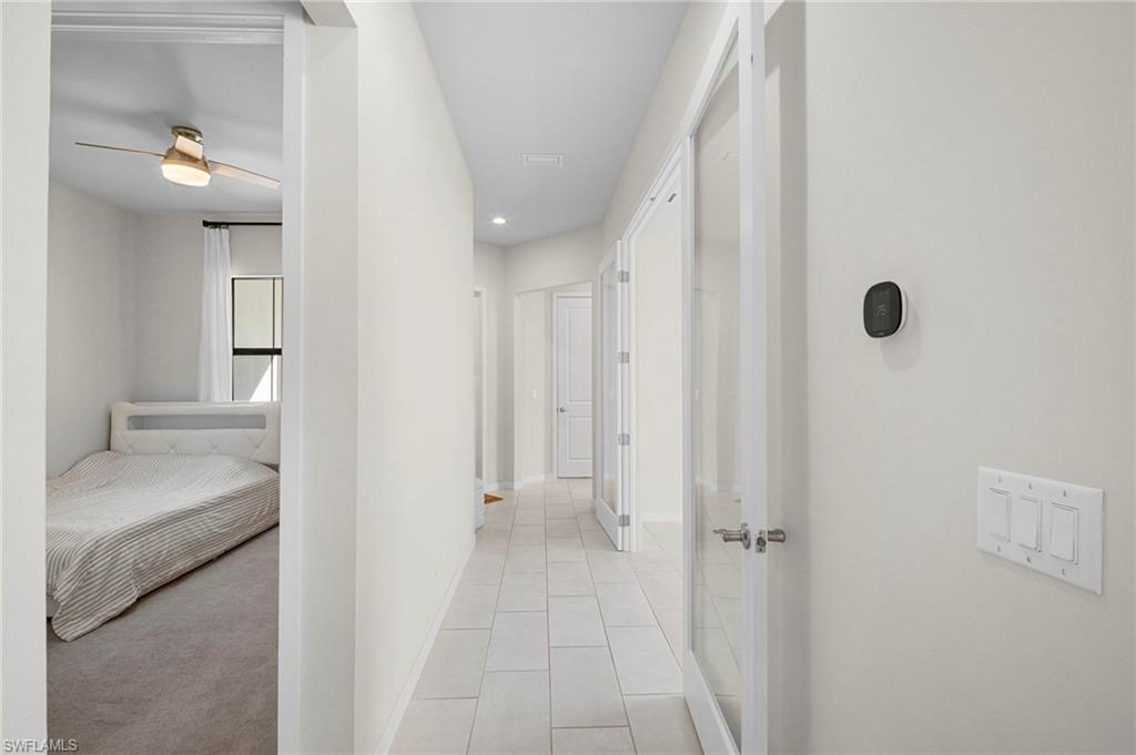 14720 Kingfisher Loop Naples, FL 34120 - Photo 35 of 50 Corridor with recessed lighting and light tile patterned floors