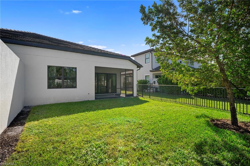 14720 Kingfisher Loop Naples, FL 34120 - Photo 37 of 50 Back of property featuring stucco siding, a fenced backyard, and a sunroom