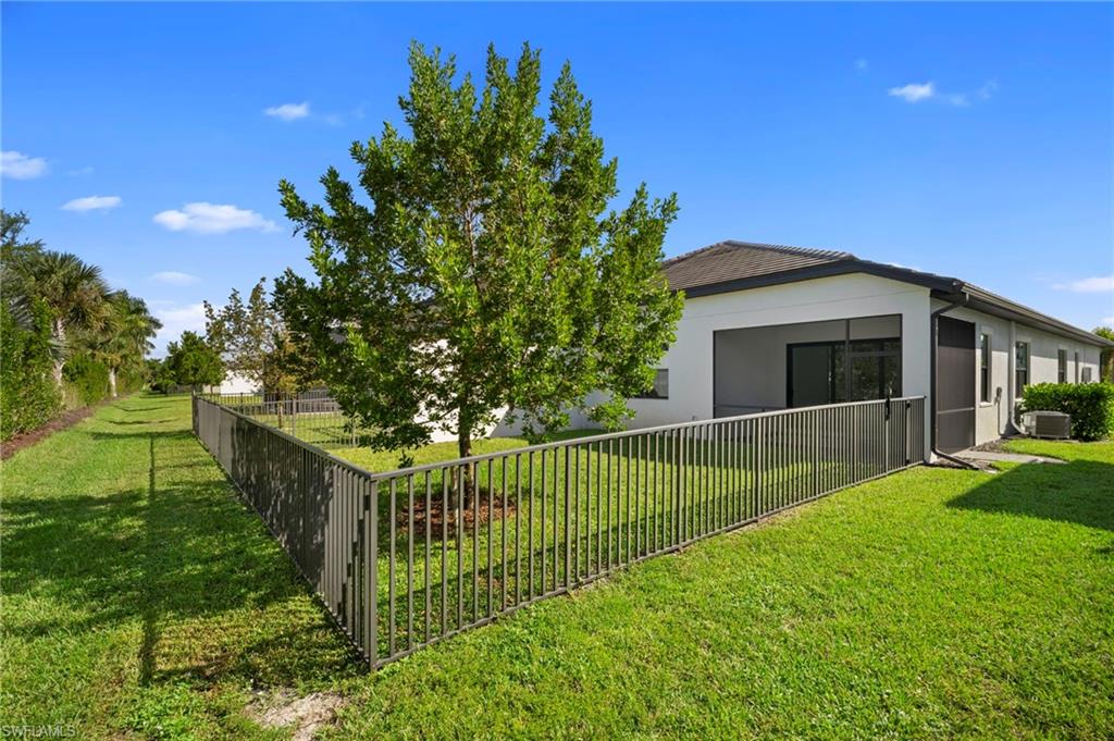 14720 Kingfisher Loop Naples, FL 34120 - Photo 38 of 50 Back of property with stucco siding and a sunroom
