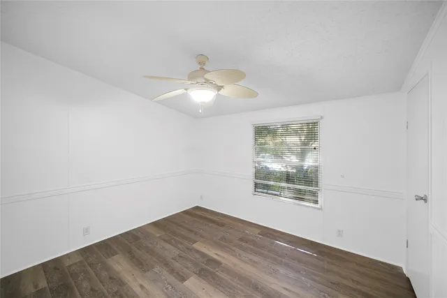 an empty room with wooden floor mirror and window
