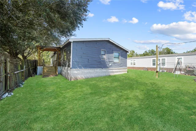 a view of a backyard with table and chairs and wooden fence