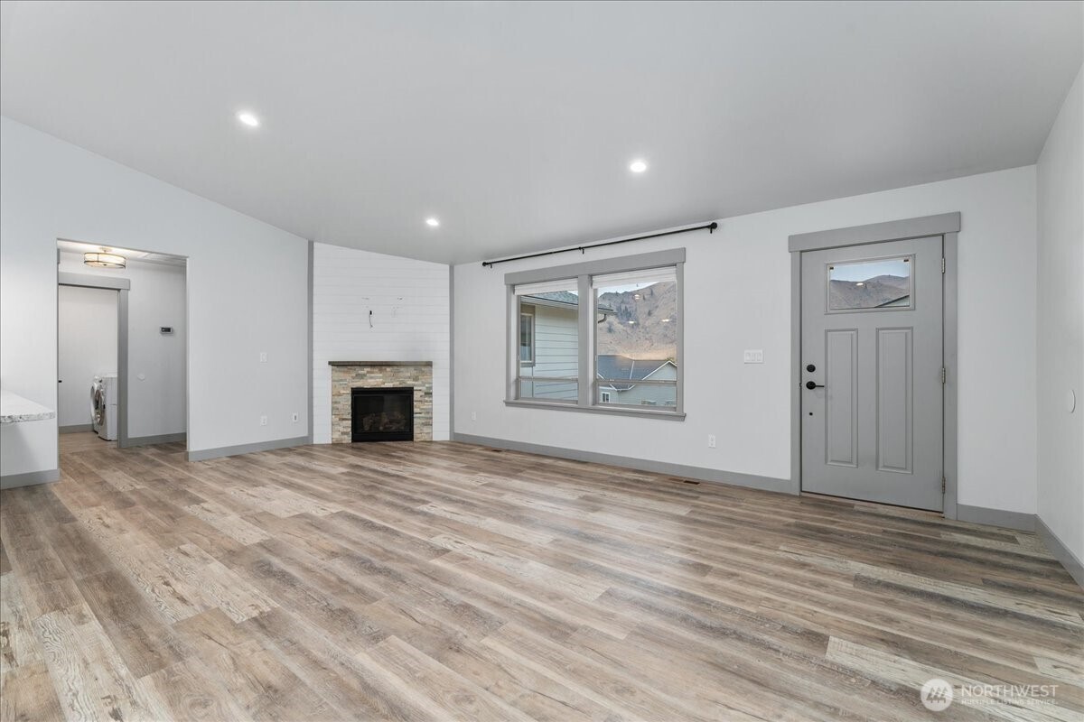 9978 Saska Way Entiat, WA 98822 - Photo 2 of 35 a view of empty room with wooden floor and fireplace