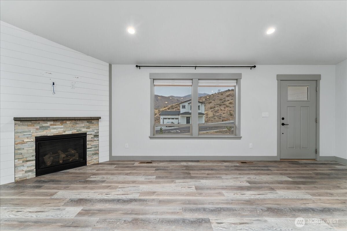 9978 Saska Way Entiat, WA 98822 - Photo 3 of 35 a view of an empty room with wooden floor and a fireplace