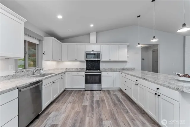 a kitchen with granite countertop white cabinets and white appliances