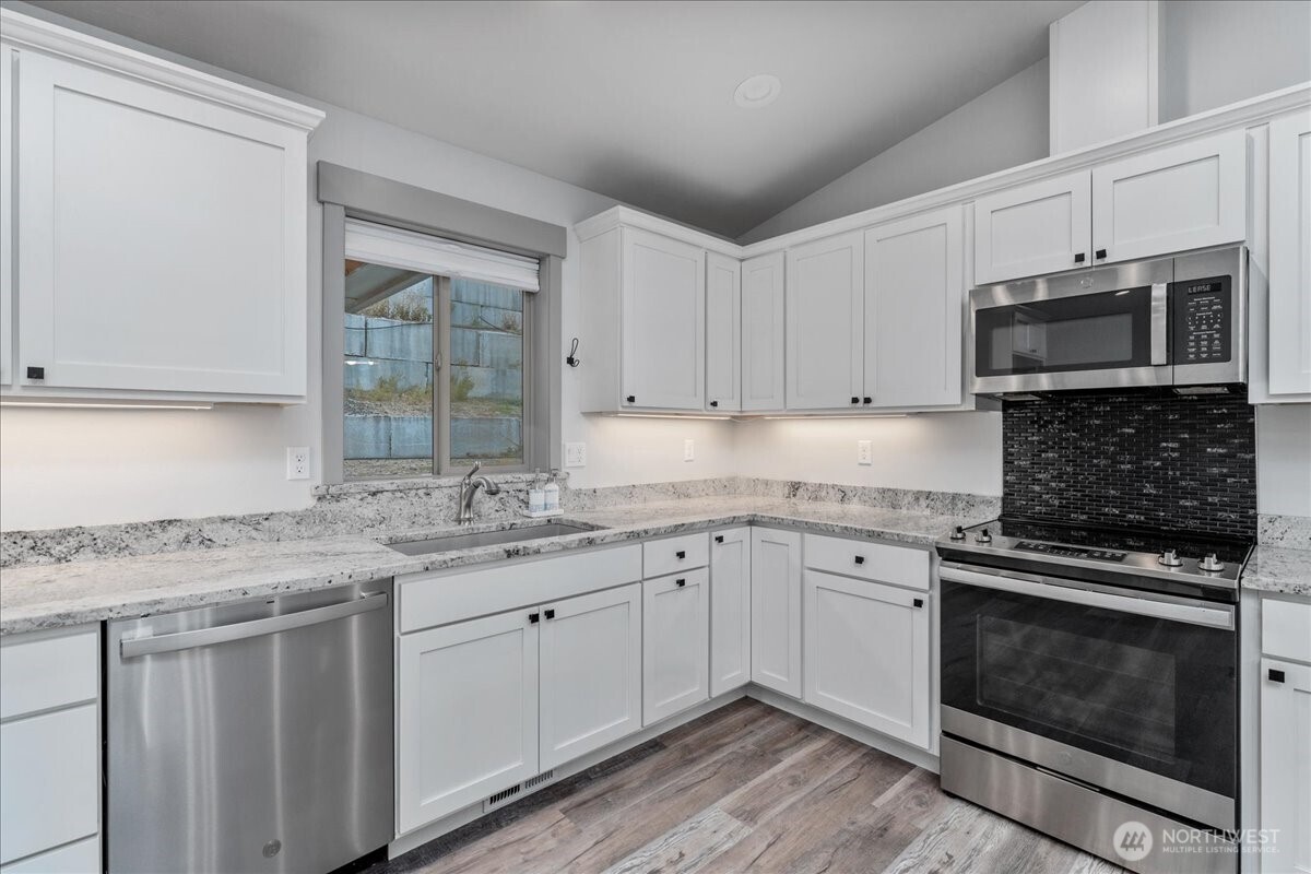 9978 Saska Way Entiat, WA 98822 - Photo 5 of 35 a kitchen with stainless steel appliances granite countertop a stove microwave and cabinets