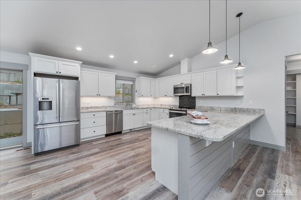 9978 Saska Way Entiat, WA 98822 - Photo 6 of 35 a kitchen with stainless steel appliances granite countertop a sink dishwasher a refrigerator and a stove with wooden floor