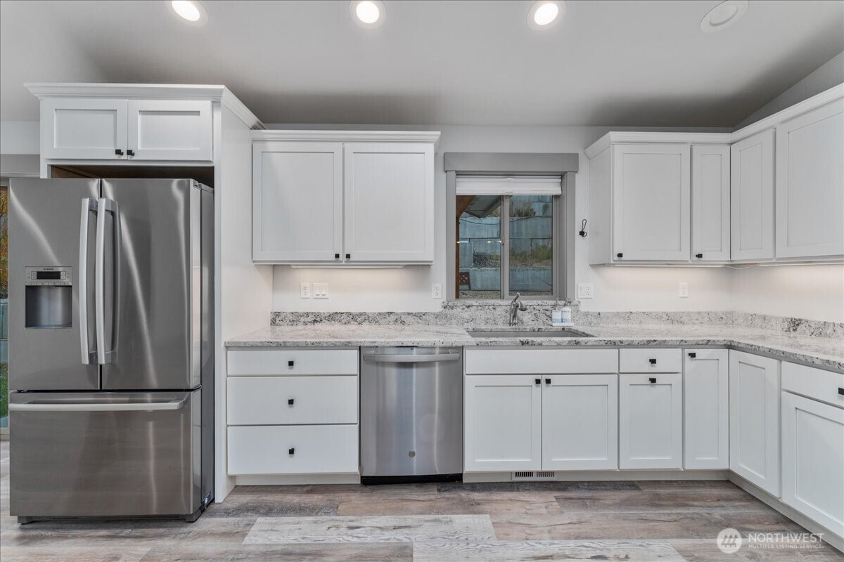9978 Saska Way Entiat, WA 98822 - Photo 7 of 35 a kitchen with granite countertop a refrigerator sink and cabinets