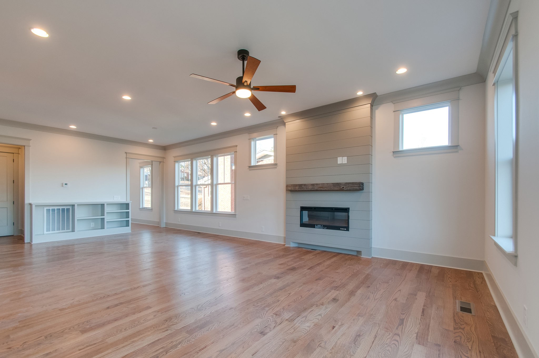 931 Mitchell Road Nashville, TN 37206 - Photo 8 of 39 an empty room with wooden floor fireplace and windows