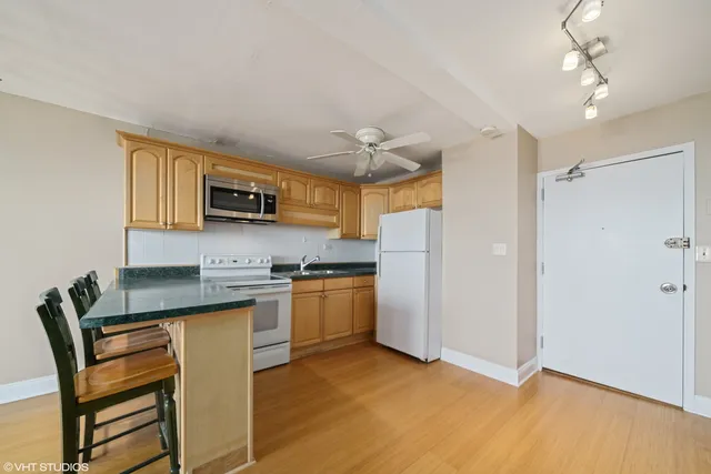 a kitchen with stainless steel appliances granite countertop a stove refrigerator and a sink