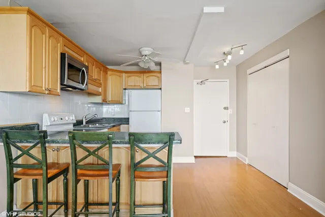 a kitchen with stainless steel appliances granite countertop a stove top oven a sink dishwasher and a microwave