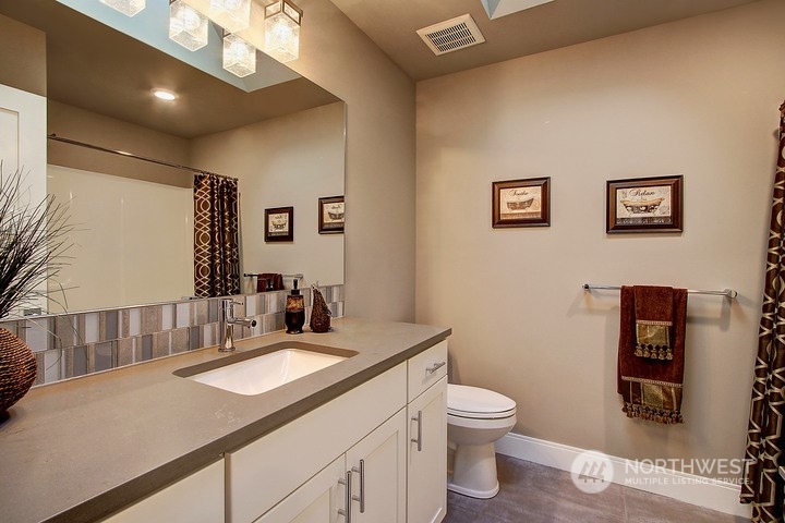 3123 234th Street Southeast Bothell, WA 98021 - Photo 8 of 26 a bathroom with a granite countertop toilet sink and mirror