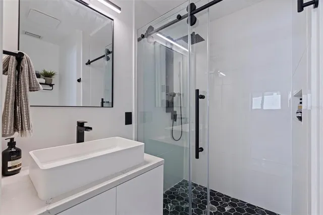 a bathroom with a sink a toilet a mirror and shower