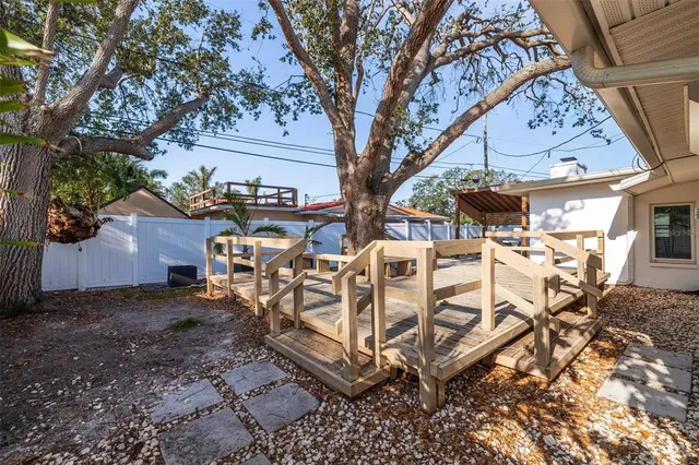 a view of a backyard with a bench and trees