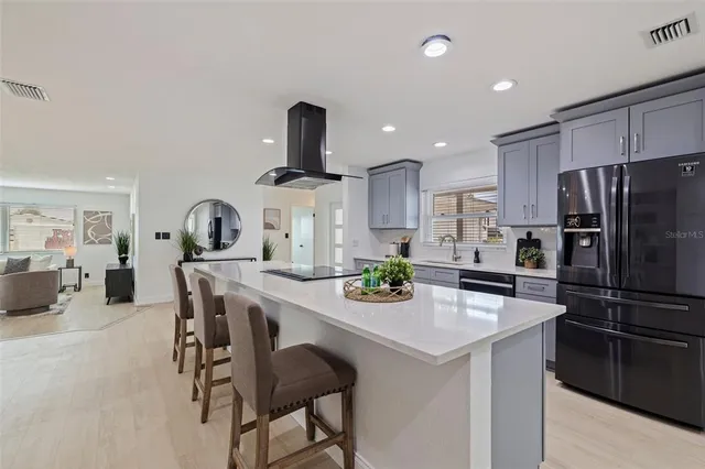 a kitchen with kitchen island a stove a table and chairs