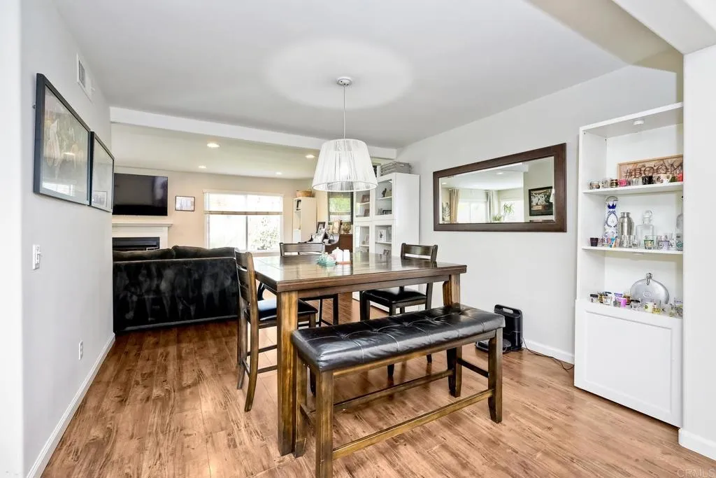2425 Torrejon Place Carlsbad, CA 92009 - Photo 31 of 61 a living room with furniture and a dining table with wooden floor