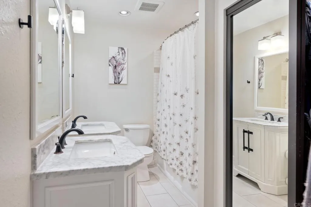 2425 Torrejon Place Carlsbad, CA 92009 - Photo 38 of 61 a bathroom with a sink a mirror a shower and a mirror