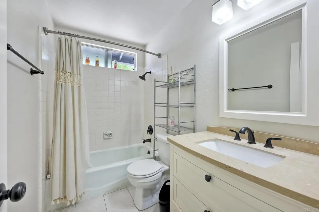 2425 Torrejon Place Carlsbad, CA 92009 - Photo 40 of 61 a bathroom with a granite countertop sink toilet a mirror a vanity and shower