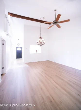 an empty room with wooden floor and white walls