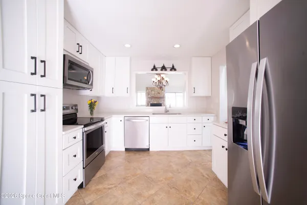 a kitchen with stainless steel appliances a refrigerator sink and microwave