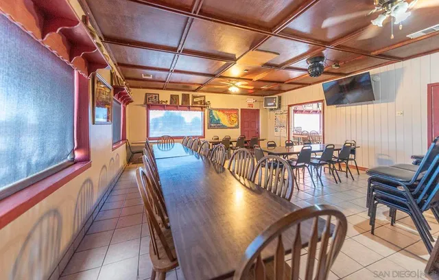 a view of a dining room with furniture floor to ceiling window and potted plants
