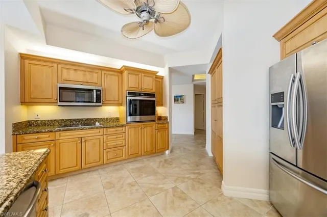 a kitchen with stainless steel appliances granite countertop a refrigerator and a stove top oven