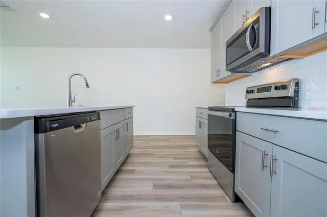 a kitchen with stainless steel appliances granite countertop a sink and a microwave