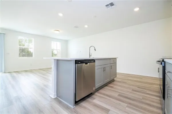 a kitchen with a sink cabinets and wooden floor