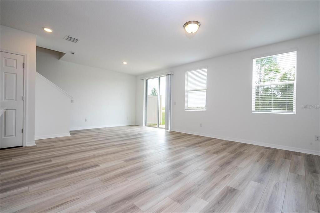 4549 Burrowing Owl Loop St. Cloud, FL 34772 - Photo 13 of 48 a view of an empty room with wooden floor and a window