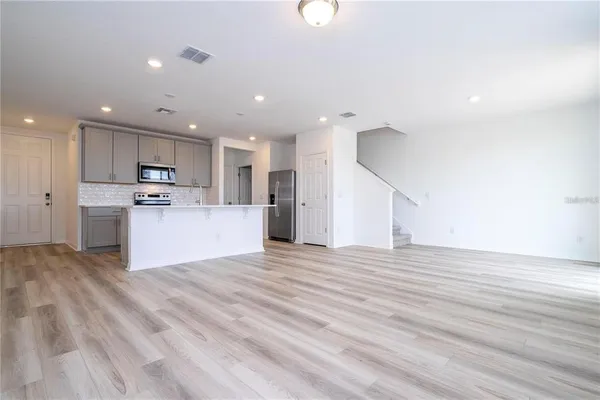a view of kitchen with kitchen island microwave and cabinets