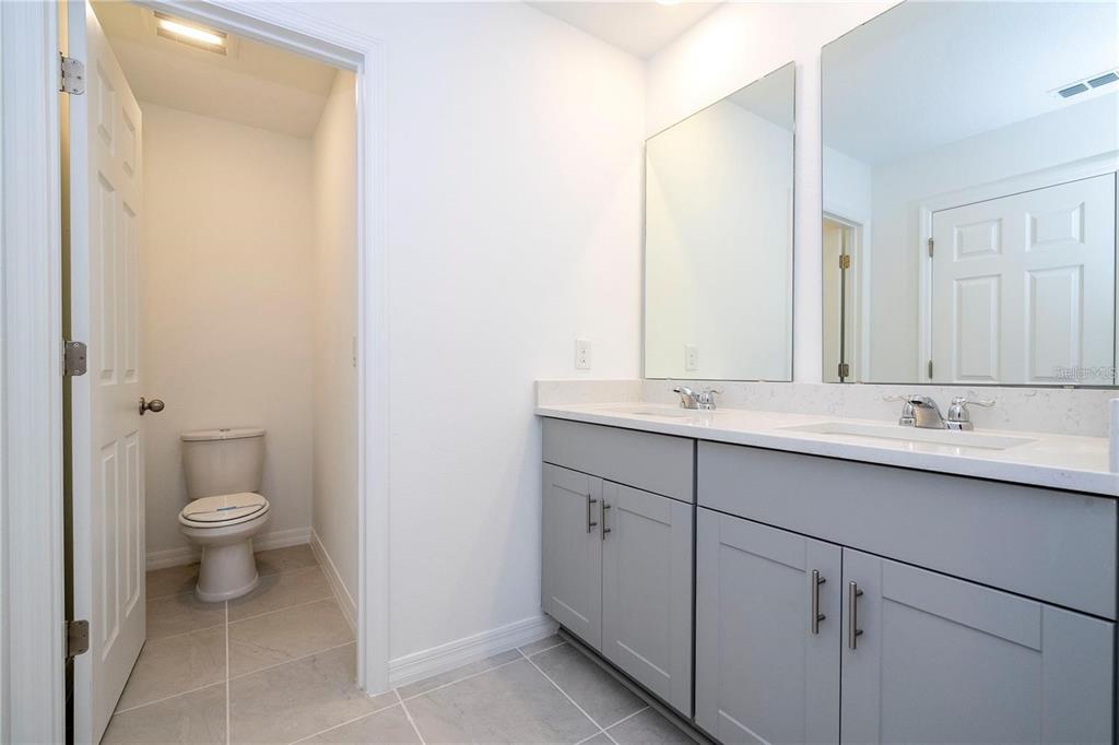 4549 Burrowing Owl Loop St. Cloud, FL 34772 - Photo 23 of 48 a bathroom with a toilet sink and mirror