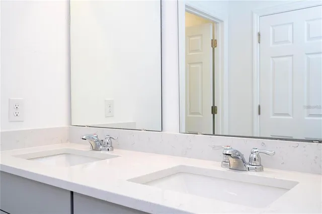 a bathroom with a double vanity sink and a mirror