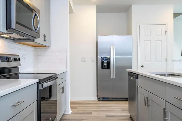 a kitchen with stainless steel appliances granite countertop a refrigerator and a sink