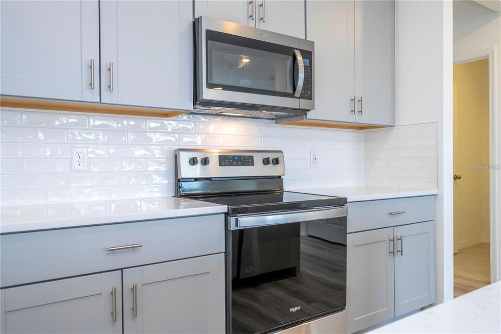 4549 Burrowing Owl Loop St. Cloud, FL 34772 - Photo 5 of 48 a kitchen with stainless steel appliances granite countertop white cabinets stove a sink and dishwasher