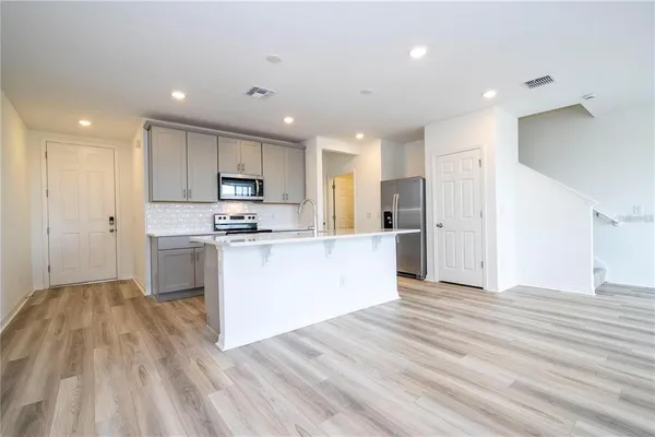 a large kitchen with kitchen island a sink stainless steel appliances and cabinets