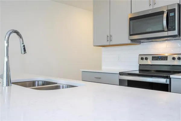 a kitchen with stainless steel appliances granite countertop a sink and a microwave