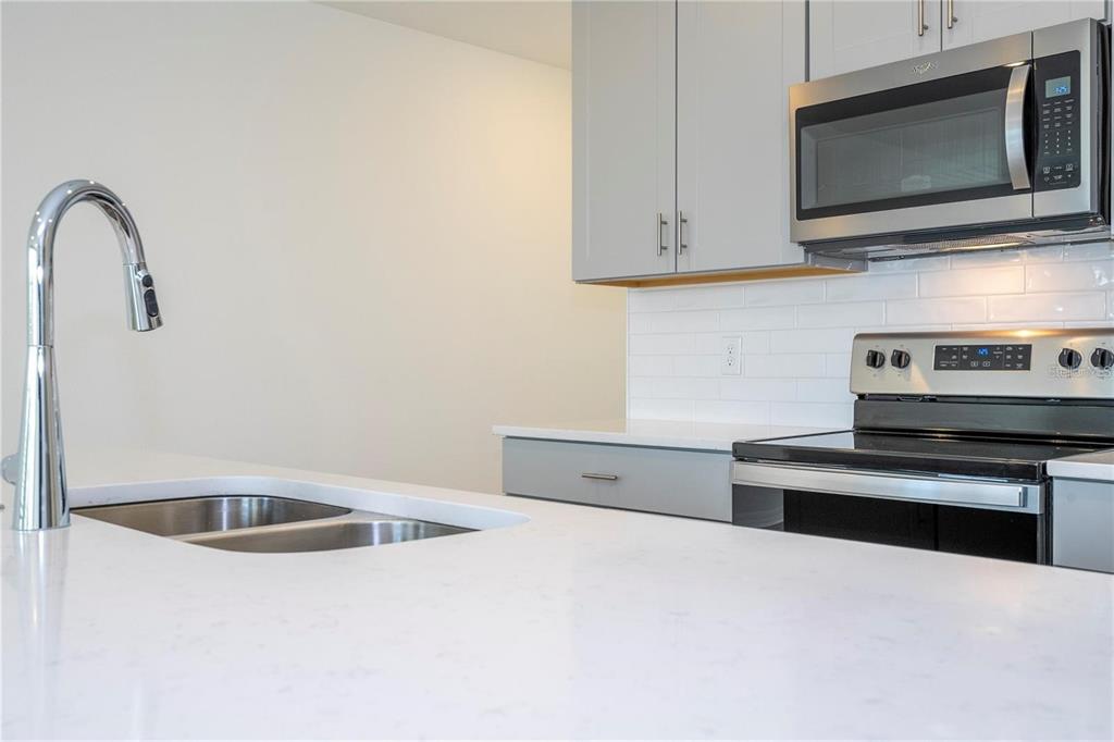 4549 Burrowing Owl Loop St. Cloud, FL 34772 - Photo 8 of 48 a kitchen with stainless steel appliances granite countertop a sink and a microwave