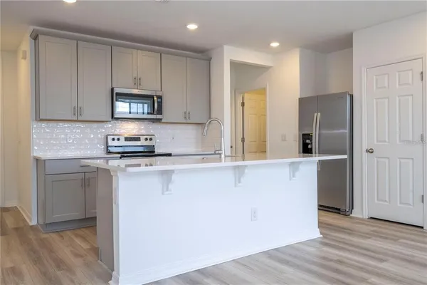 a kitchen with stainless steel appliances granite countertop a refrigerator sink and microwave